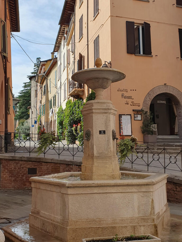 A historic stone fountain by Albero La Rocca in Brisighella