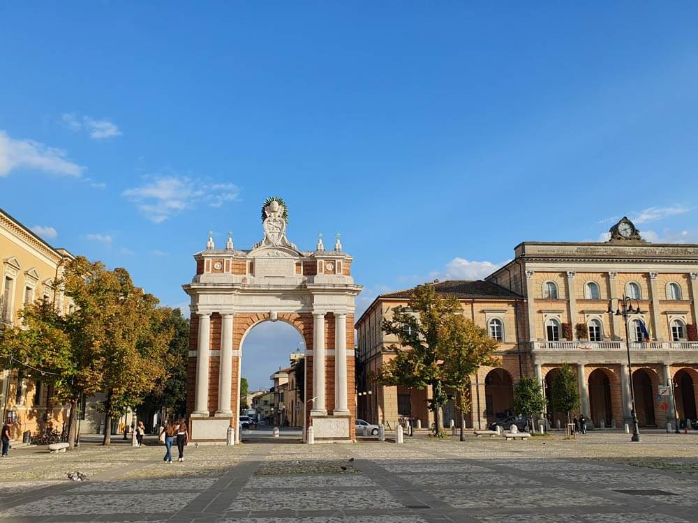 A view of the wide square Piazza Ganganelli in Santarcangelo di Romagna, and of the triumphal arch standing in an open space