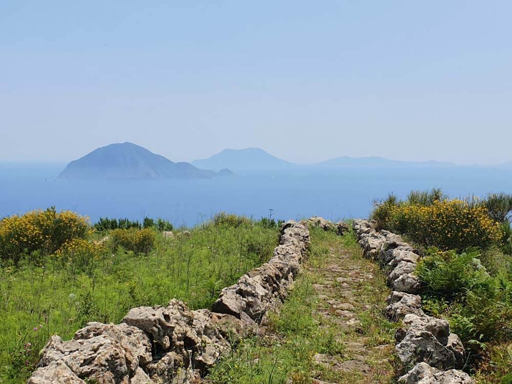 Stone footpath high above the sea with misty islands in the background