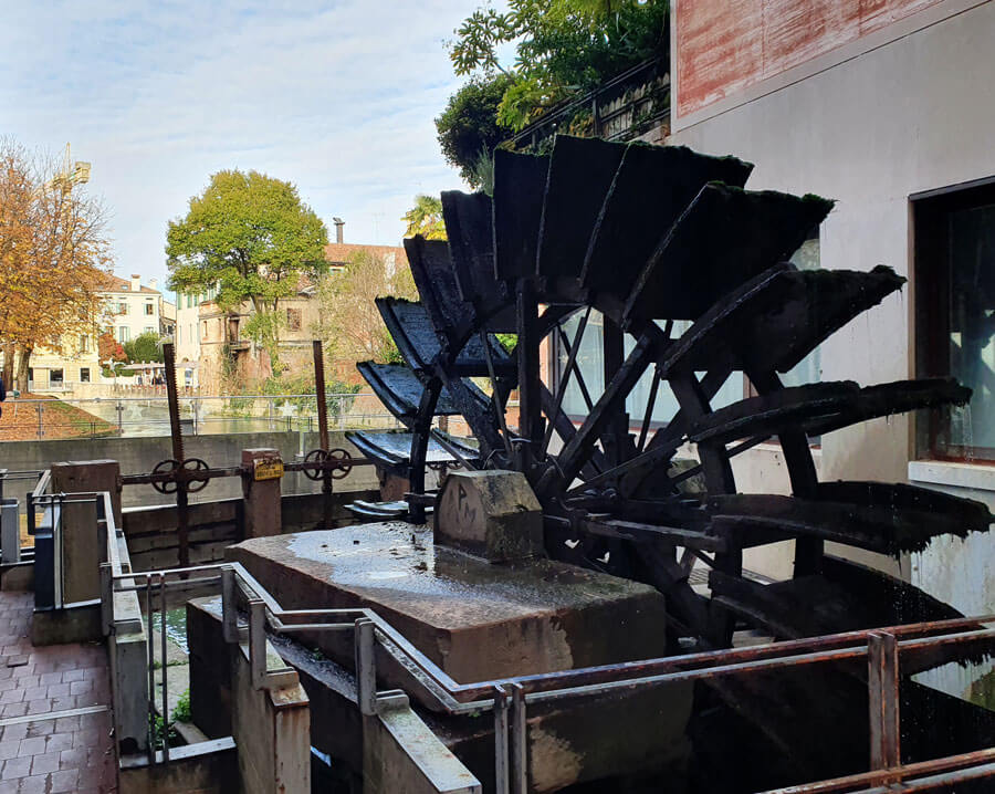 A waterwheel in front of a canal view, Treviso