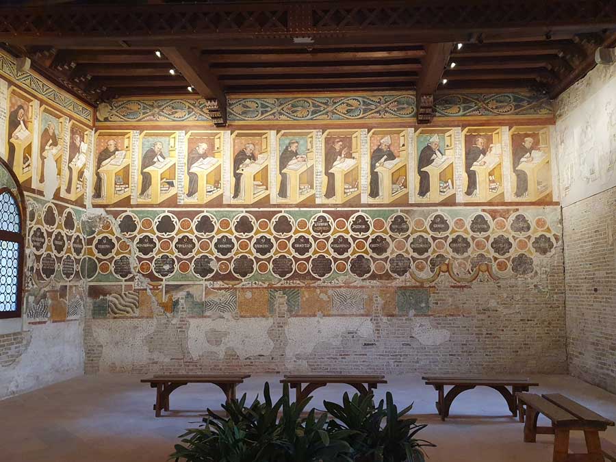 Interior of the Sala del Capitolo with a view of  the painted frieze by Tomaso da Modena showing monks working at desks