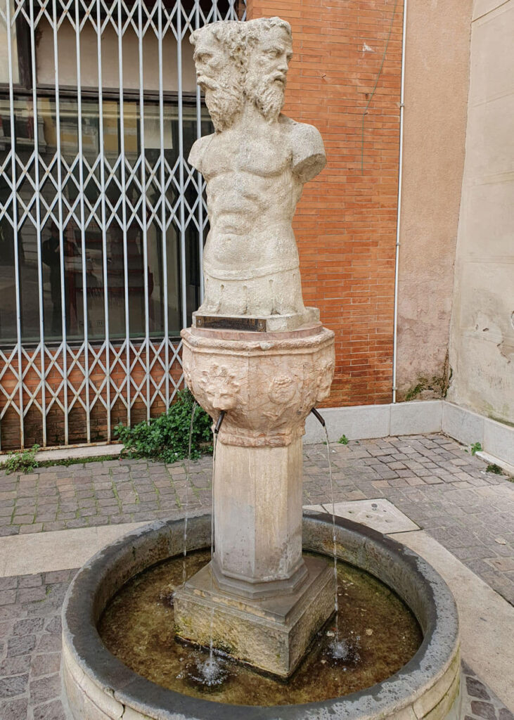 The Fountain of Three Faces, Treviso; a drinking water fountain with four spouts topped by a sculpture of a male torso with three faces