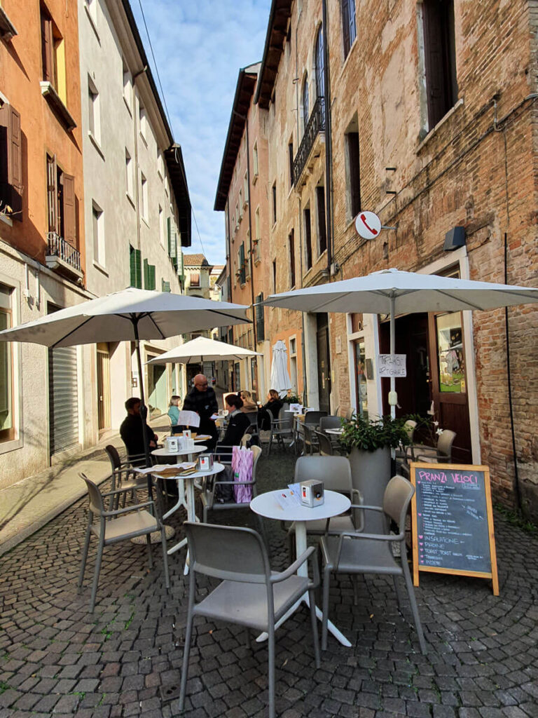 Café tables on a narrow cobbled street in Treviso