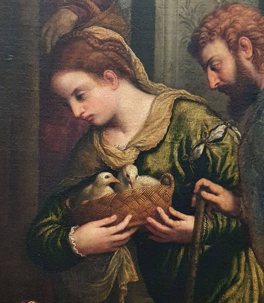 Detail from a painting by Paris Bordon portraying a young woman in green holding two doves in a basket