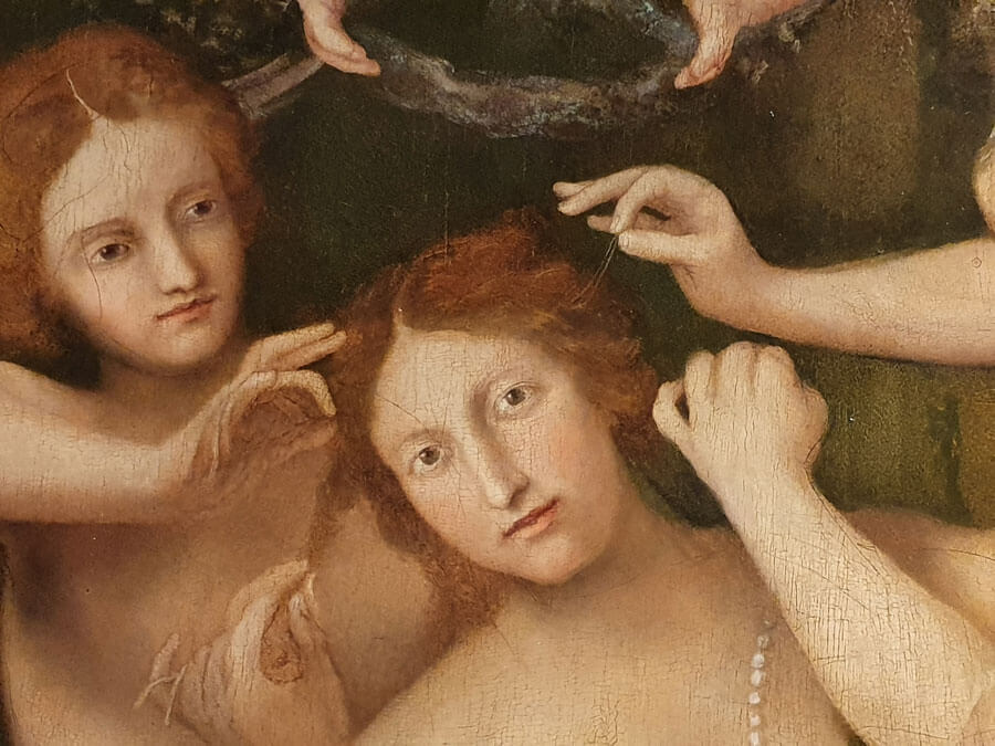 A painting by Lorenzo Lotto of a beautiful woman (Venus) having her hair tended by the hands of other women, the Three Graces